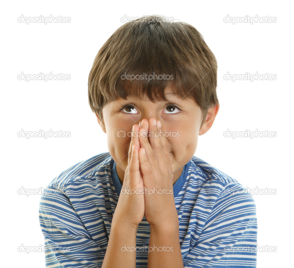 Young boy looks up with hands together