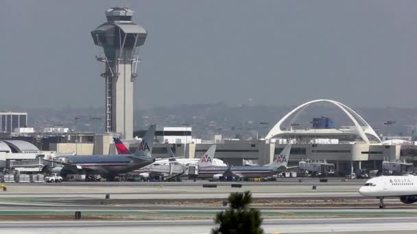 Samolot taksówek obok wieży na lotnisku w los angeles — Wideo stockowe