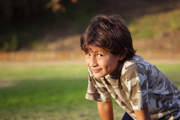 Feliz menino sorridente no parque perto do pôr-do-sol — Fotografia de Stock