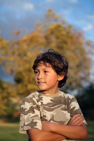 Feliz niño sonriente en el parque cerca de la puesta del sol —  Fotos de Stock