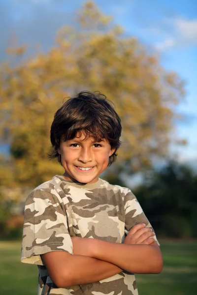 Feliz menino sorridente no parque perto do pôr-do-sol — Fotografia de Stock