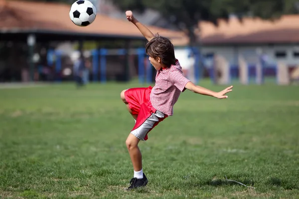 Junge spielt Fußball oder Fußball im Park — Stockfoto