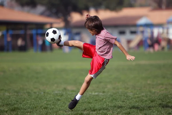 公園でサッカーをしている少年は — ストック写真