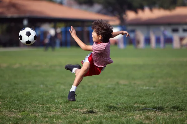 Chłopiec gra w piłkę nożną w parku — Zdjęcie stockowe