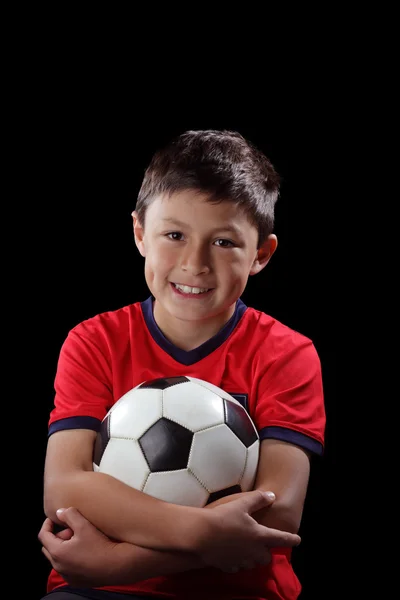 Niño con balón de fútbol sobre fondo negro — Foto de Stock