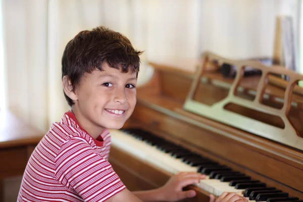 Ung pojke spela piano — Stockfoto