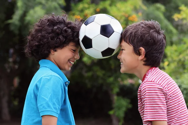 Deux jeunes garçons jouant avec un ballon de football — Photo