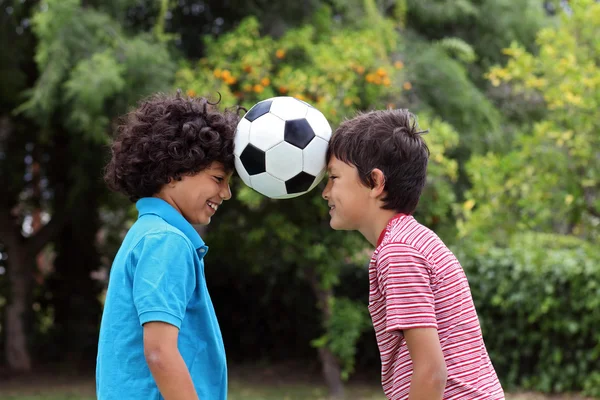 Два мальчика играют в футбол с мячом. — стоковое фото