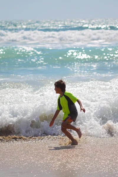 Jonge jongen speelt bij het strand — Stockfoto