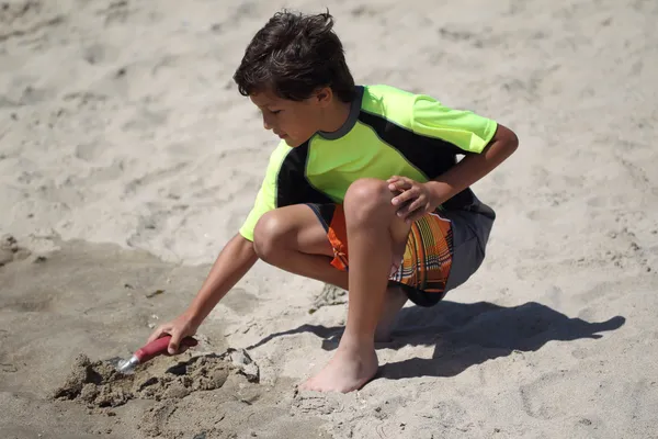 Jeune garçon joue sur la plage — Photo