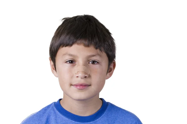 Jeune garçon avec du plâtre sur le nez - sur fond blanc — Photo