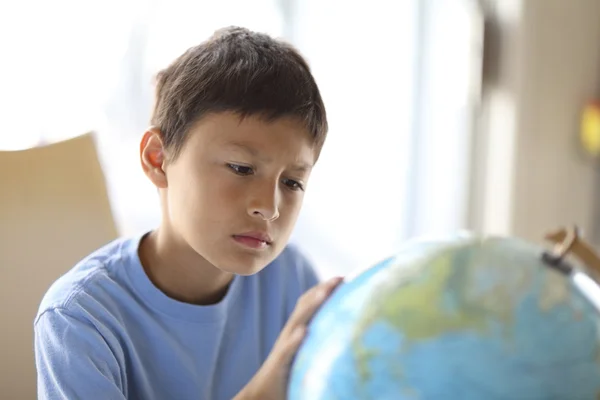 Мальчик смотрит на глобус — стоковое фото