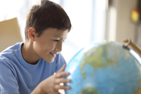 Jongen op zoek naar een globe — Stockfoto