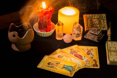 Tarot kartları, mumlar, tütsü ve diğer objelerle dolu bir hayat bir kehanet seansı sırasında siyah kart masasında. Tarot kartlı kehanet oturumu kavramı.