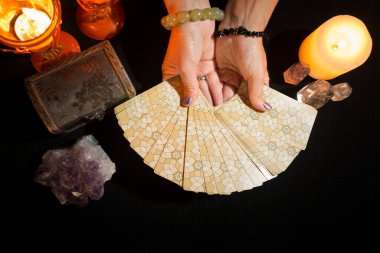 Tarot kartları gösteren bir kadının ellerinin ayrıntıları. Tarot kartlarıyla fal baktırma seansı. Yukarıdan görüntüle.