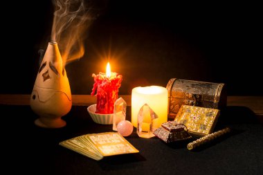 Tarot kartları, mumlar, tütsü ve diğer objelerle dolu bir hayat bir kehanet seansı sırasında siyah kart masasında. Tarot kartlı kehanet oturumu kavramı.