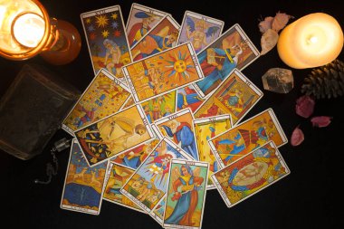 Bir grup tarot kartı, siyah kart masasının üzerinde dağınık bir şekilde duruyor. Tarot kartlı kehanet oturumu. Yukarıdan görüntüle.