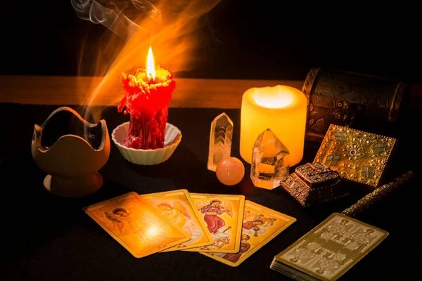 Tarot kartları, mumlar, tütsü ve diğer objelerle dolu bir hayat bir kehanet seansı sırasında siyah kart masasında. Tarot kartlı kehanet oturumu kavramı.