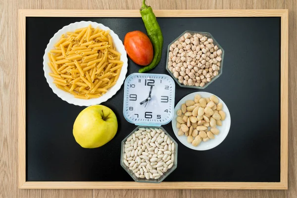 健康的な食べ物と黒板の時計 間欠的な断食についての概念的な写真 オートファジーの再生メカニズムなどの利点をもたらす食事療法 — ストック写真