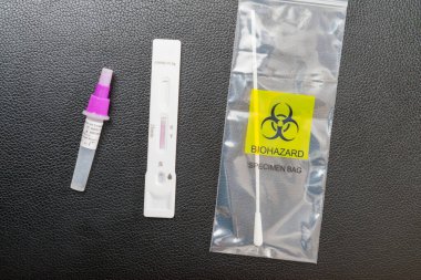 Malzeme Covid19 antijen test kitine dahil, evde, siyah arka planda kendi kendini test etmek için gerekli..