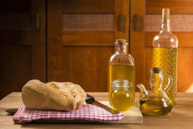 Ekmek, birkaç şişe ve ekstra saf zeytinyağlı konteynırlarla dolu sade bir masa..