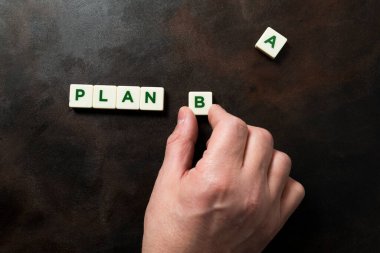 PLAN B ifadesini oluşturan bir elin ayrıntıları harf parçalarıyla A harfi ayrı görünür. İkinci şans, dayanıklılık ve kararlılık kavramı. Koyu arkaplan ve kopyala.