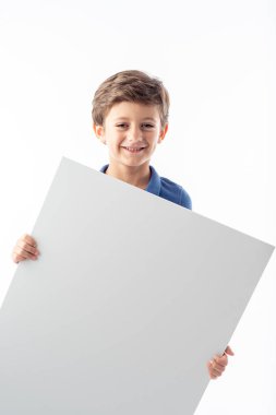 Beyaz arka planda beyaz bir reklam afişi gösteren gülümseyen beyaz çocuk..