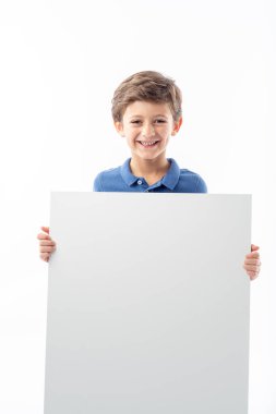 Beyaz arka planda beyaz bir reklam afişi gösteren gülümseyen beyaz çocuk..