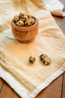 Bir kase bıldırcın yumurtasıyla bir kumaş üzerinde hayat. Görüş açısı 45 derece. Boşluğu kopyala.