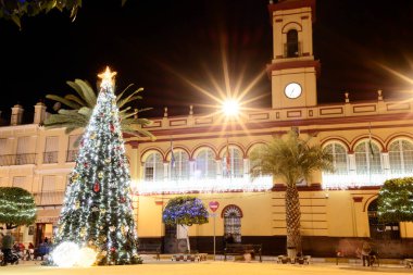 Arahal (Sevilla). İspanya. 14 Aralık 2021. Bir kasaba meydanında Noel ağacı ve şehir Noel süslemeleri. Güney İspanya 'da bir köyde şehir Noel sahnesi.