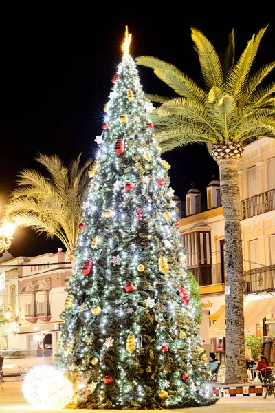 Arahal (Sevilla). İspanya. 14 Aralık 2021. Bir kasaba meydanında Noel ağacı ve şehir Noel süslemeleri. Güney İspanya 'da bir köyde şehir Noel sahnesi.
