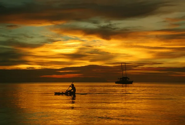 Парусник на море, человек на прекрасном золотом закате — стоковое фото