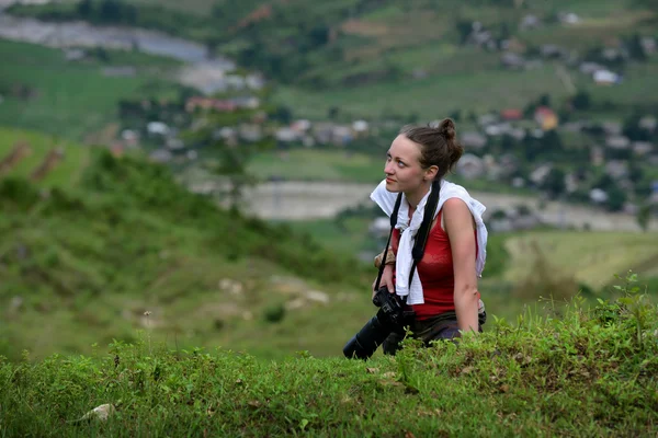 Photographer girl climbs a mountain — Stock Photo, Image