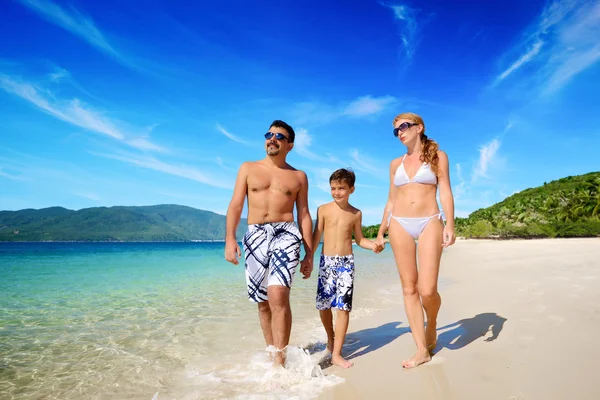 Happy family walks on sandy tropical beach shore. — Stock Photo, Image