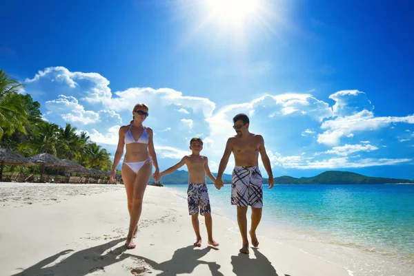 Glückliche Familie spaziert am weißen Sandstrand entlang — Stockfoto