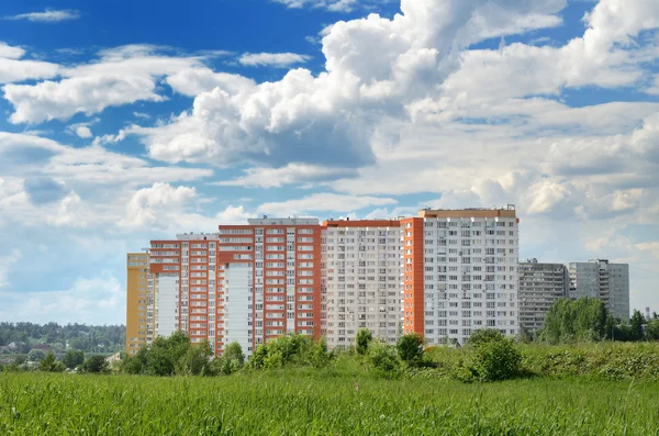 Mo yakın yeşil bir alanda modern 17 katlı sarı-turuncu ev — Stok fotoğraf