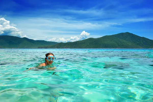 Chica feliz con una máscara flotando en el mar tropical azul —  Fotos de Stock