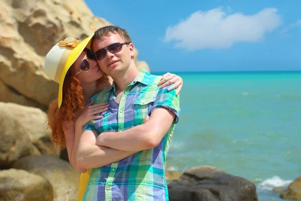 Joven hermosa pareja enamorada de pie juntos en la costa soleada . — Foto de Stock