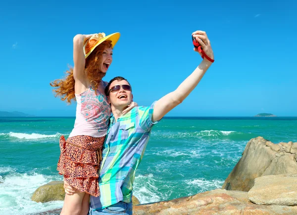Lyckliga paret tar ett foto på en strand på semester — Stockfoto