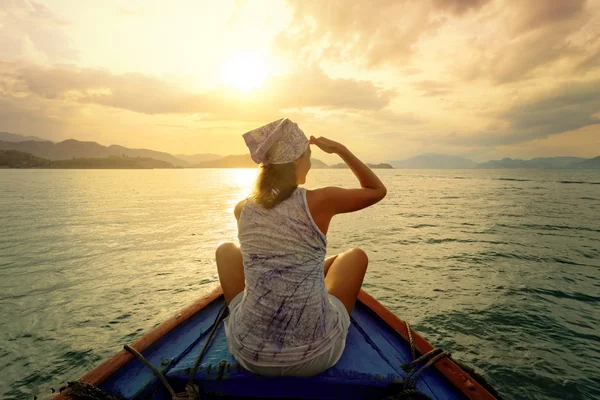 女性は島々 の間日没でボートで旅行 ストック画像