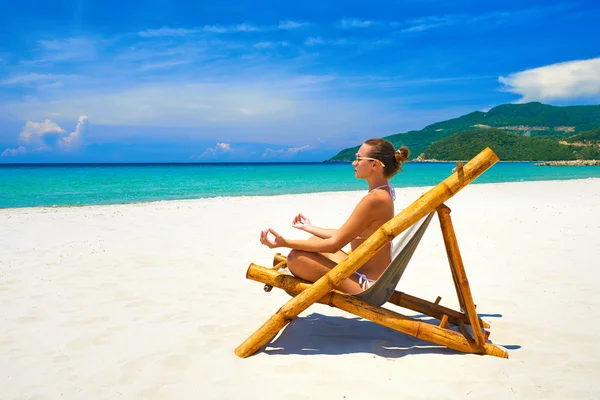 Mladá žena v pozice jógy na krásné pláži. — Stock fotografie