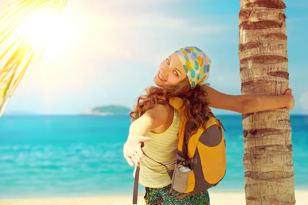 Young woman smile standing with backpack on coast sea and looki — Stock Photo, Image