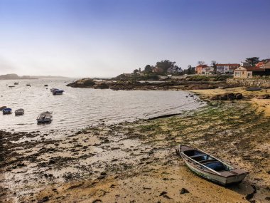 Arousa Adası 'ndaki Carbonera plajında demirli tekneler ve deniz kenarları var.