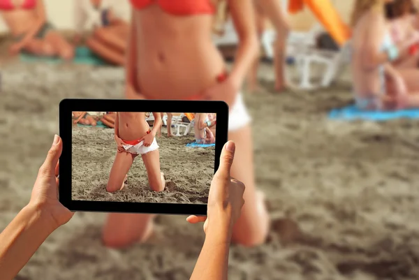 Mujer tomando fotos en una tableta Chicas en una playa —  Fotos de Stock
