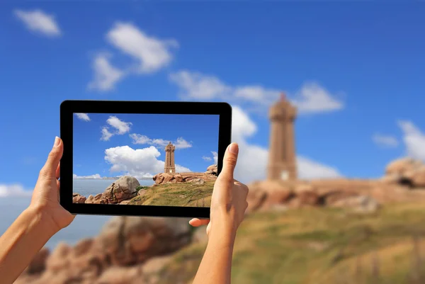 Woman taking pictures on a tablet lighthouse — Stock Photo, Image