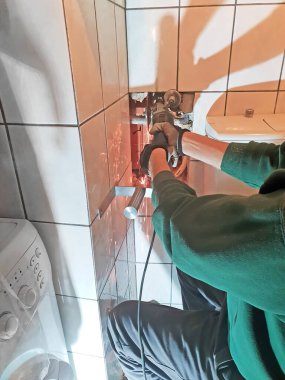 Tesisatçı banyoda eski su borularını öğütücü ve tesisat konseptiyle kesiyor.