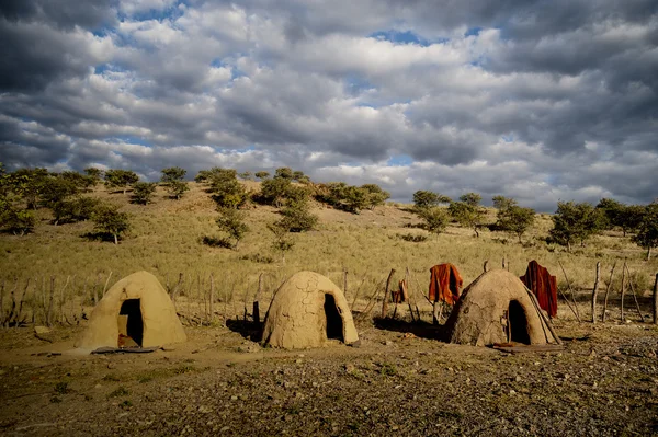 Clay bild cabanas redondas e cerca de madeira, África — Fotografia de Stock