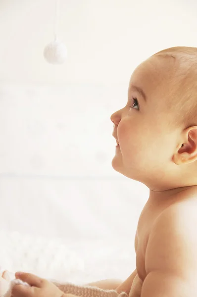 Baby sitzt auf dem Bett und sieht aus — Stockfoto