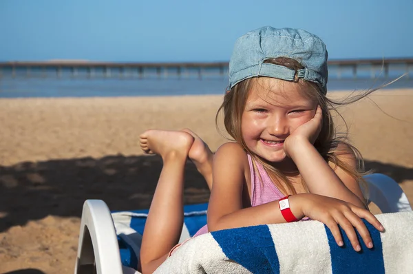 Menina deitada em uma cadeira de praia e sorrindo — Fotografia de Stock