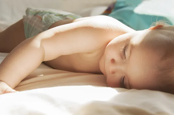 パンパース赤ちゃんのベッドに横になっています。 ストックフォト
